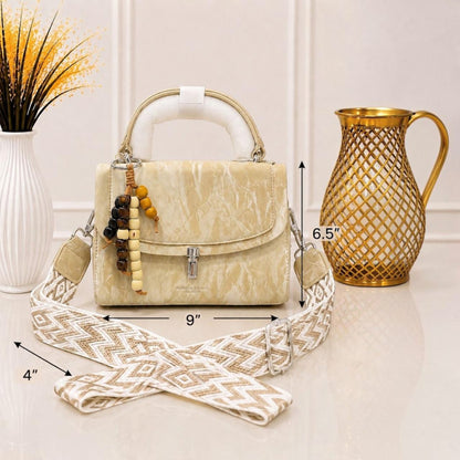 Evnique structured beige marble-effect handbag with a beaded charm and detachable woven guitar-style crossbody strap.