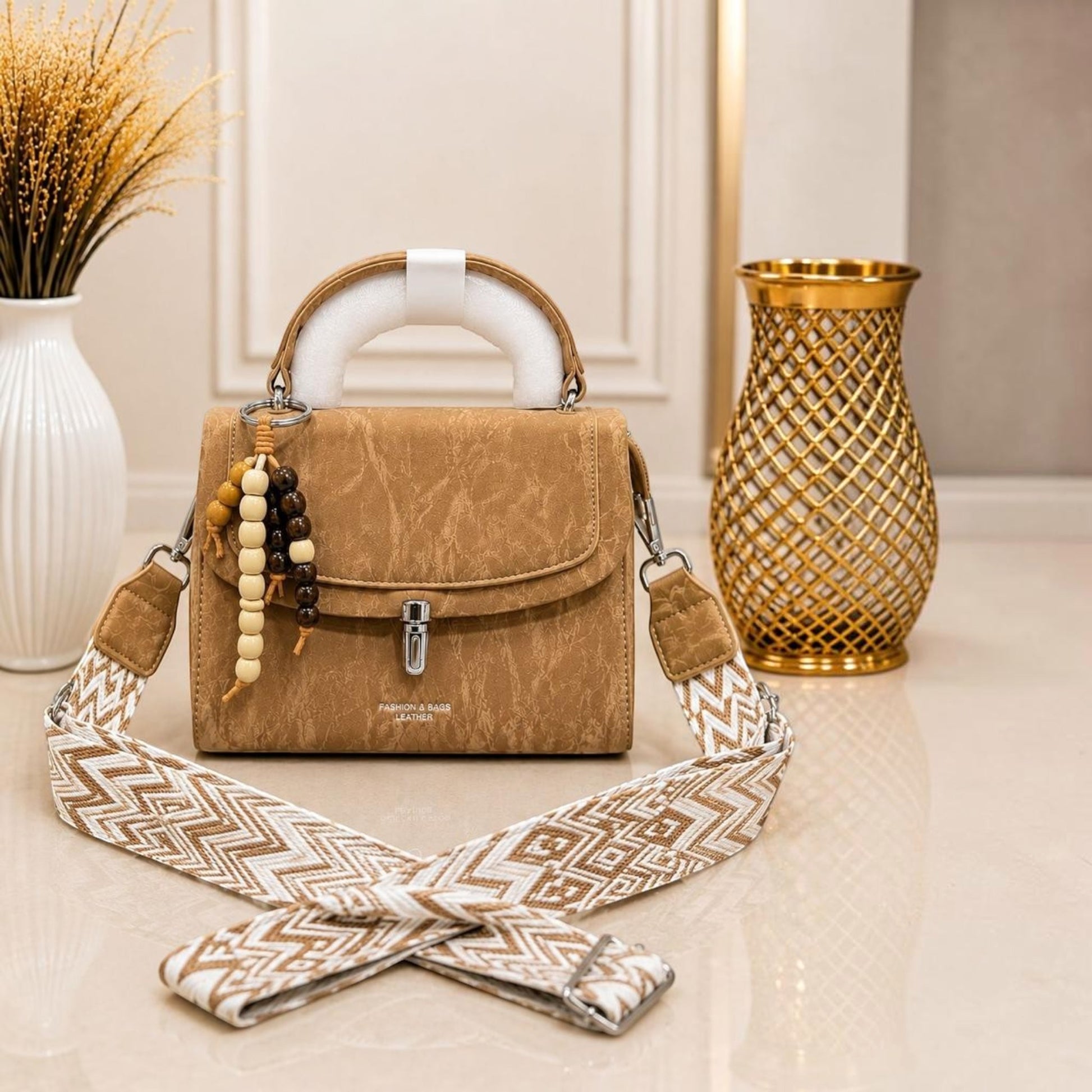 Evnique tan marble-effect structured handbag with a beaded charm and detachable woven guitar-style crossbody strap.
